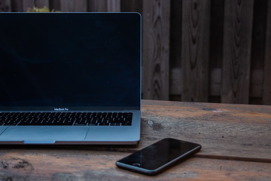 MacBook 与 iPhone 放在桌面上,用于爱思助手 Mac 版连接故障排查